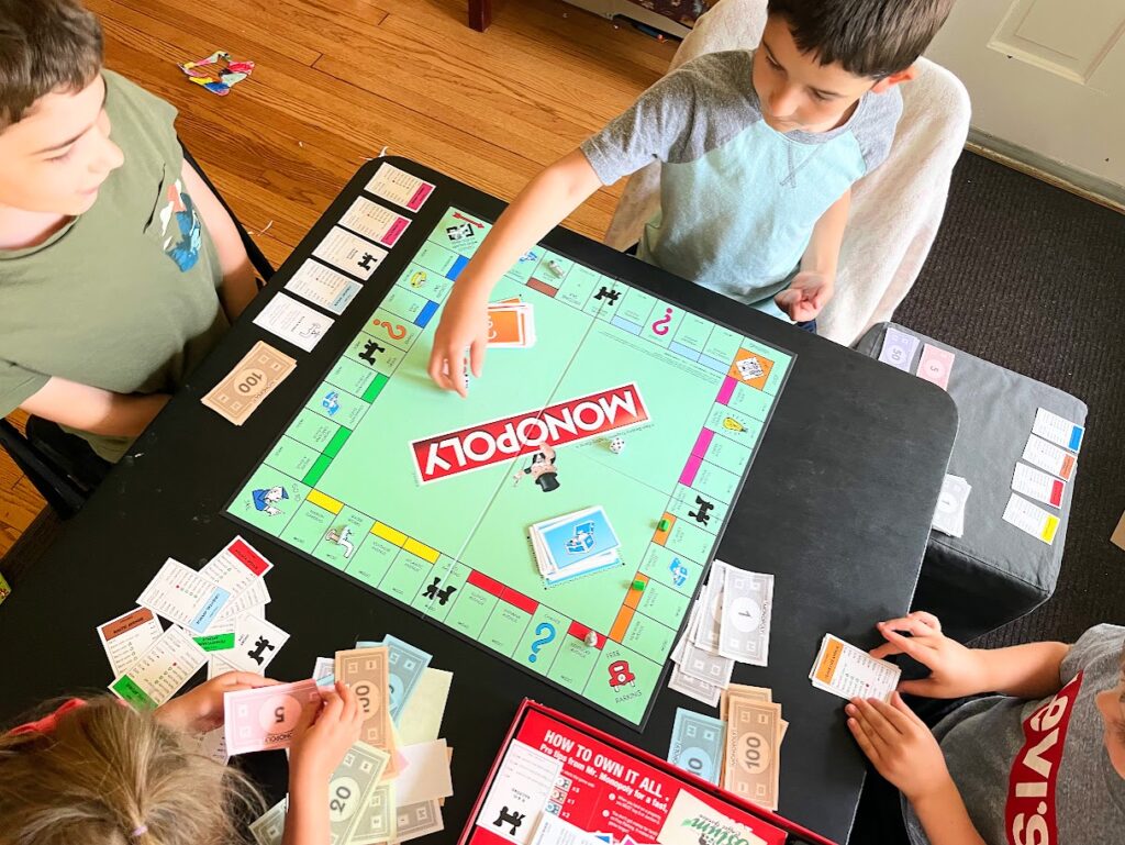 homeschool children playing monopoly together