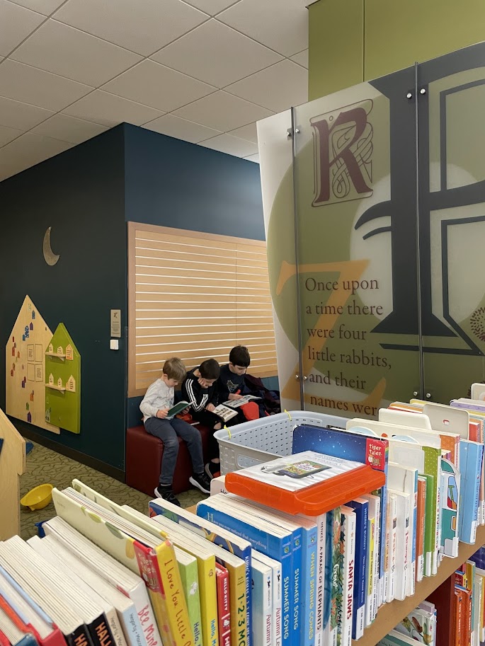 three homeschool boys reading at the library