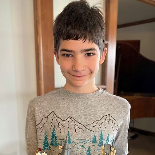 middle school boy holding a lego set