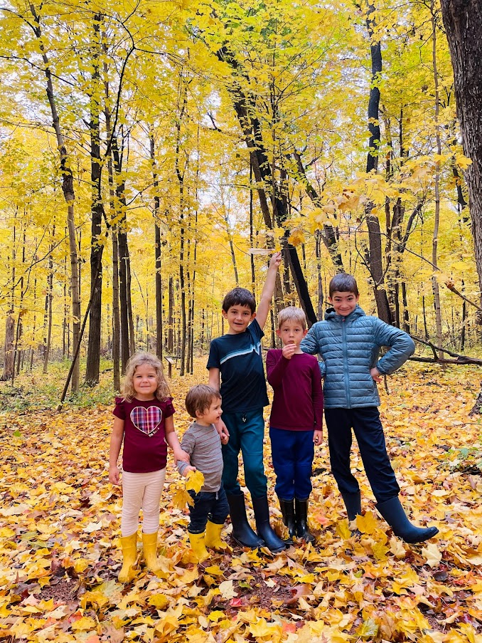 five homeschool children in the woods in autumn