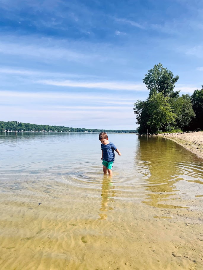 homeschool toddler boy wading in a lake