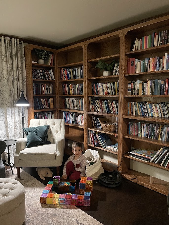 homeschool boy playing with magnets in front of a large bookshelf