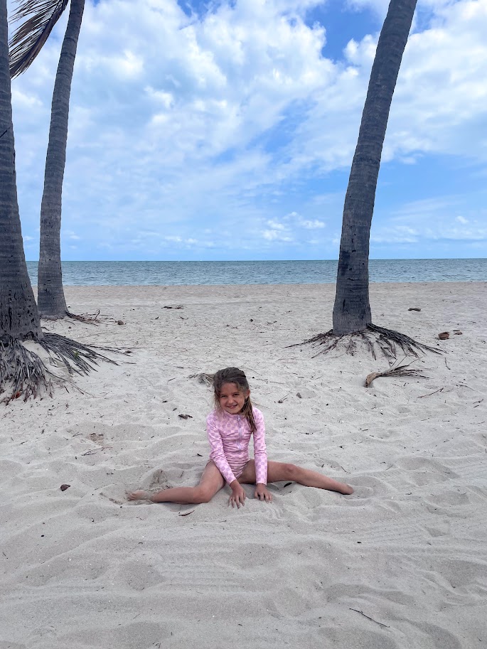 homeschooled first grade girl in the sand at the beach