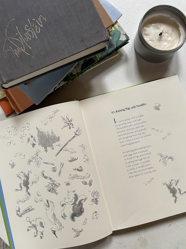 stack of childrens poetry books on coffee table near candle