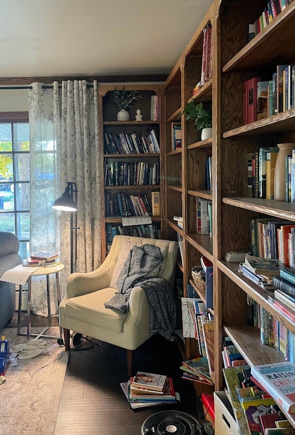 homeschool library with full bookshelves, an arm chair, and a floor lamp